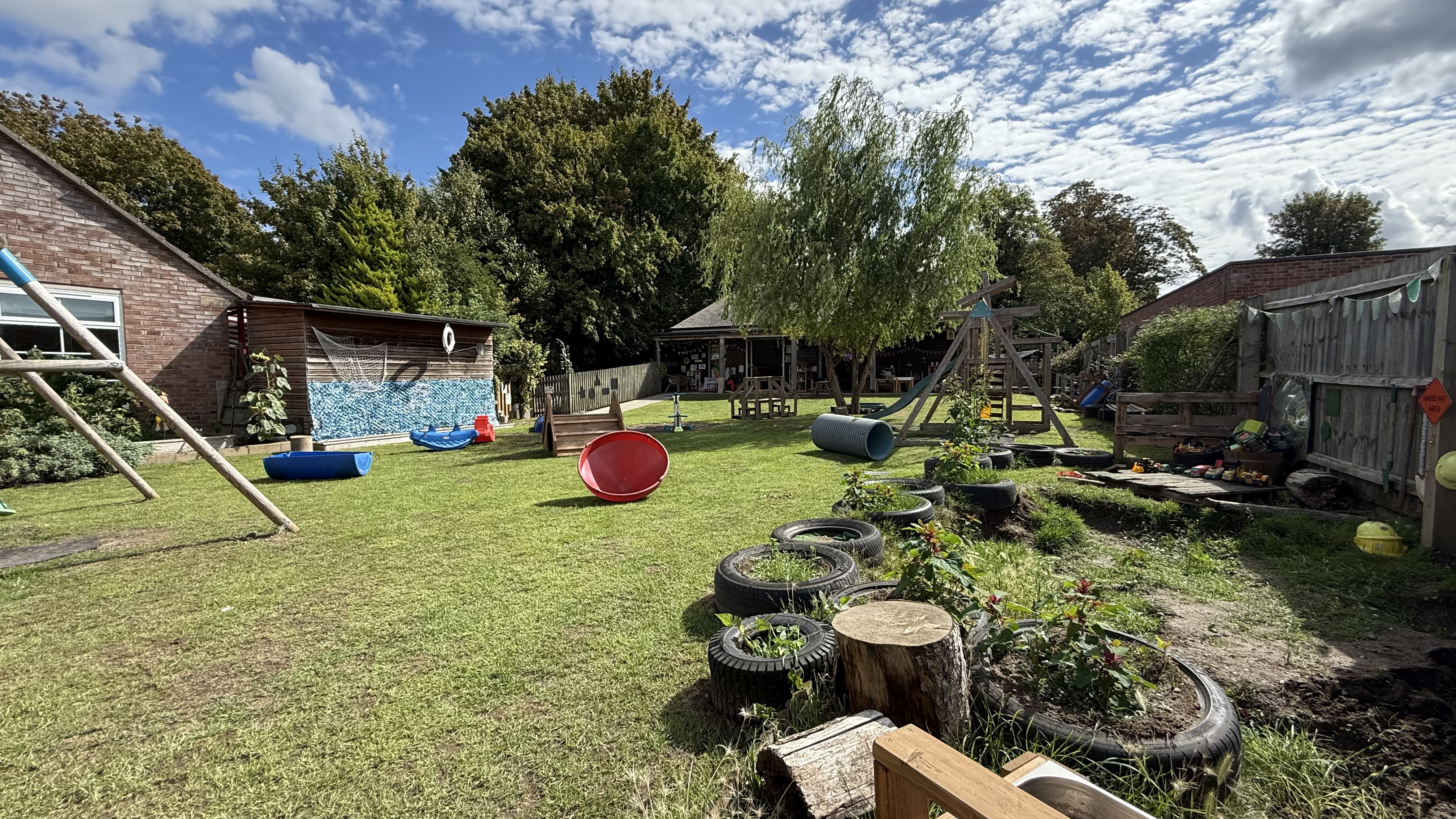 Photo of preschool garden including the building in the back and outdoor toys