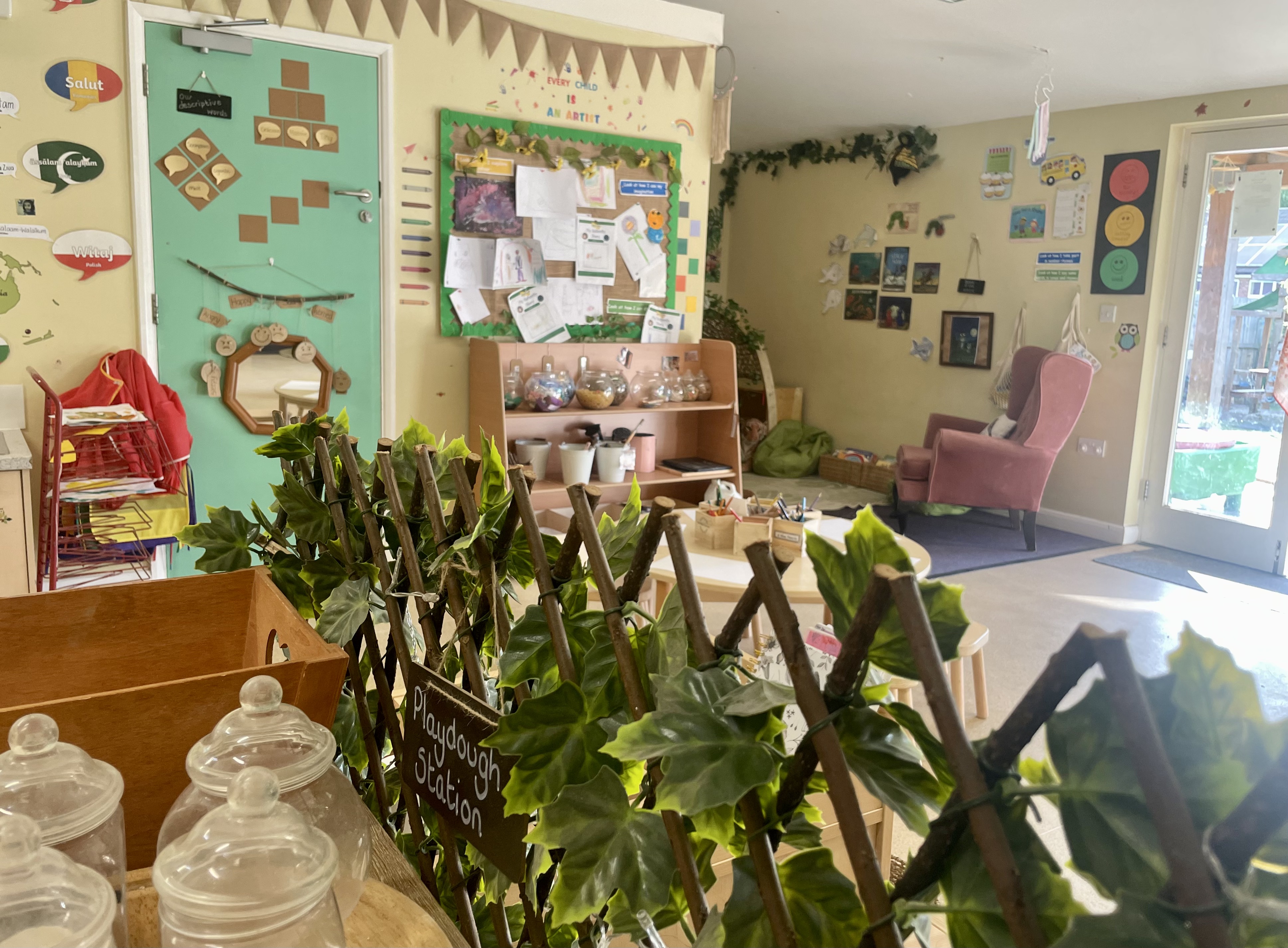 Indoor shot of preschool, showing an activity area and a reading corner in the background