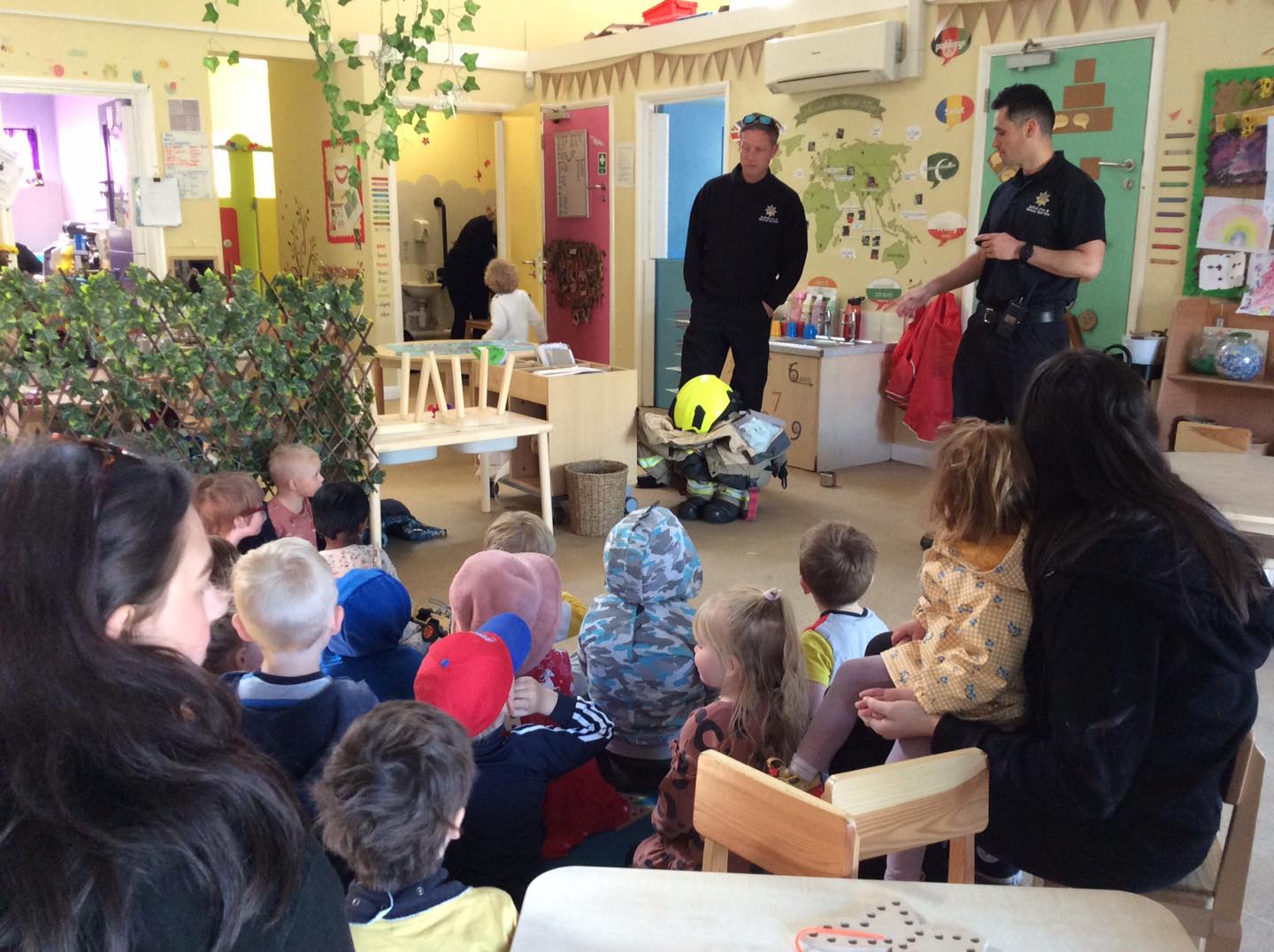 Two firemen presenting to a group of children